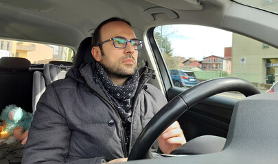 Uomo alla guida dell'automobile per le strade della città