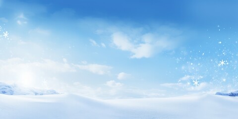A serene winter landscape with a snow-covered hillside and a clear blue sky with a few scattered clouds.