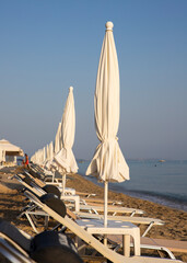 Fototapeta premium Beach with sun beds and umbrellas near the sea