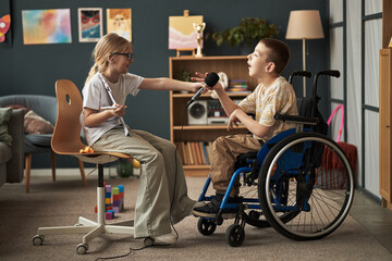 Two children engaging in playful activities with toys and microphone in a bright, decorated...