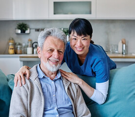 Doctor or nurse caregiver with senior man talking and having fun at home or nursing home