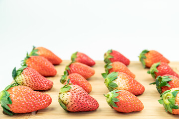 Fresh strawberries neatly arranged on the cutting board
