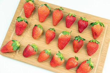 Fresh strawberries neatly arranged on the cutting board