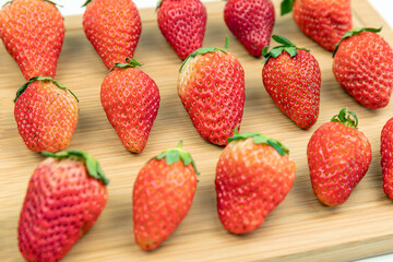 Fresh strawberries neatly arranged on the cutting board