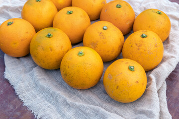 Fresh fruit, candied oranges, are neatly placed on the fabric