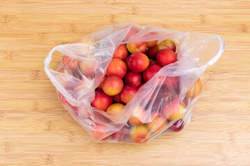Fresh red plums in a transparent plastic bag