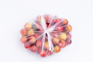 Fresh red plums in a transparent plastic bag