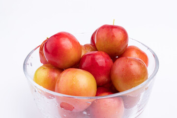 The fresh red plums in the glass bowl