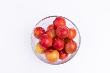 The fresh red plums in the glass bowl