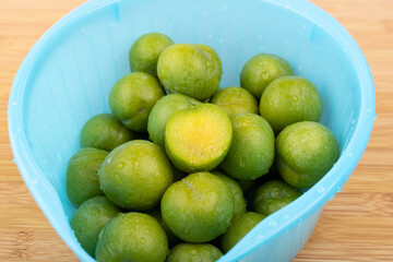 Drain the fresh plums in the basket