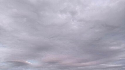 Subtle pastel gray sky with layered cloud textures, soft lighting and minimal tones ideal for backgrounds, mood boards, or atmospheric visual projects.