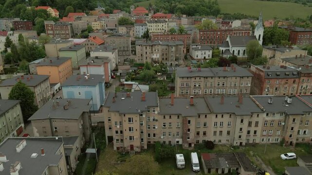 Aerial view of a suburban residential area in Bogusz&oacute;w-Gorce, Poland showing rows of detached houses with red rooftops and tree-lined streets near Chełmiec Mountain