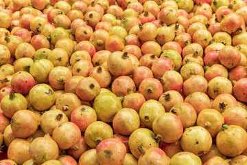 A pile of fresh orange-yellow pomegranate fruits