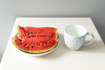 The white water cup and the watermelon in the white plate