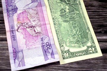 reverse sides of 200 ETB two hundred Ethiopian Birr cash money bill issued by the national Bank of Ethiopia and 2 USD two American dollars bill banknote by the Federal Reserve, exchange rate concept