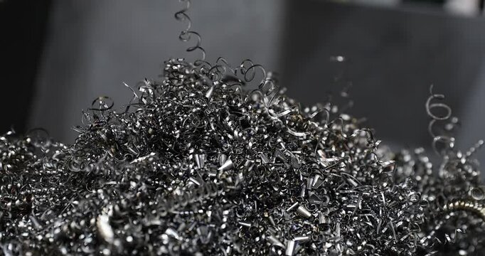 4k slow motion movie of metal shavings metal chips after a lathe operation. Metal working machine tool precision cutting process.