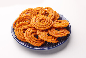 Indian Snacks popular in Diwali Festival Called Chakali serve in plate isolated on white background 