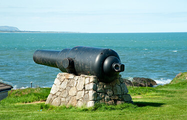 Old black cannon at harbour in Wicklow town, Ireland