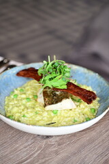 Top View of Pea Risotto with Cod and Crispy Bacon – Spring-Inspired Restaurant Dish