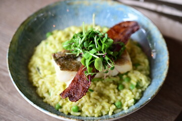 Top View of Pea Risotto with Cod and Crispy Bacon – Spring-Inspired Restaurant Dish