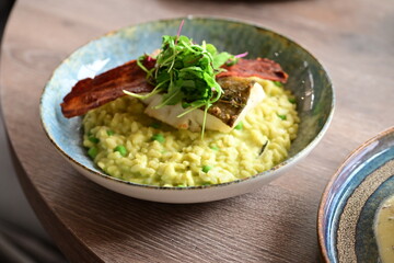 Top View of Pea Risotto with Cod and Crispy Bacon – Spring-Inspired Restaurant Dish
