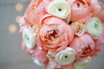 Fototapeta premium A stunning bouquet of pink and white ranunculus and roses, covered in water droplets.