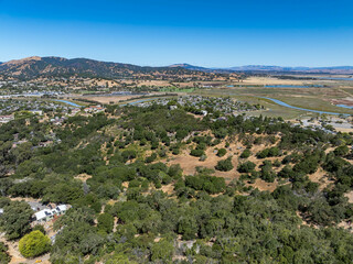 Aerial photos of a forested hillside in San Rafael, California, highlighting dense tree coverage,...