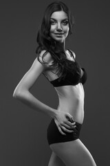 Fototapeta premium young slim girl in black lingerie on dark gray background
