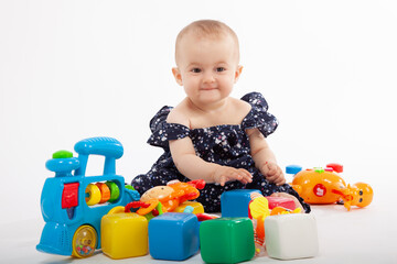 Happy Baby Playing with Colorful Toys on White Background. Early childhood development and joyful playtime.