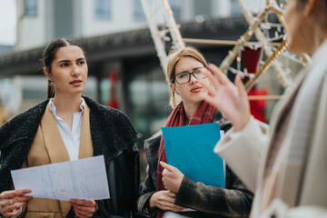 Three women collaborate on project ideas in an outdoor setting showing professionalism and...
