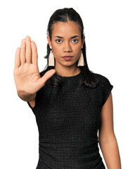 Young Filipina in black evening dress standing with outstretched hand showing stop sign, preventing...