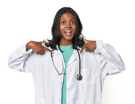 Young Indian doctor with stethoscope surprised pointing with finger, smiling broadly.