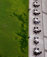outdoor cafe tables from abow and green grass, vertical