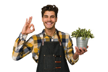 Young caucasian gardener man isolated on white background cheerful and confident showing ok gesture.