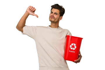 Young caucasian man holding a plastic trash isolated feels proud and self confident, example to...