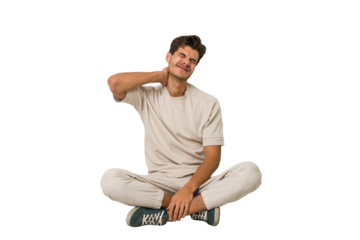 Young caucasian man sitting on the floor isolated on white background suffering neck pain due to sedentary lifestyle.