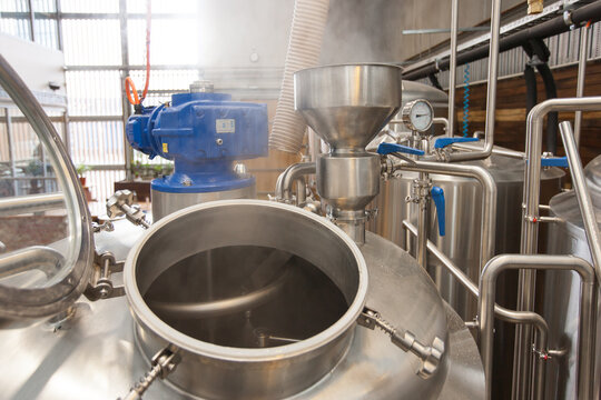 Steam escaping from hatch of a stainless steel tank at a microbrewery