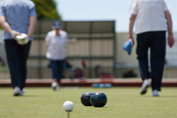 Older woman walking up and down the lawn bowls green