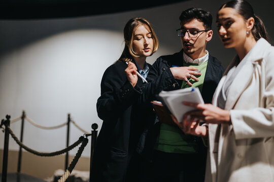 Group of people engaged in a discussion while exploring a museum, showcasing collaboration and intellectual exchange in an educational and cultural setting, reflecting curiosity and shared learning in