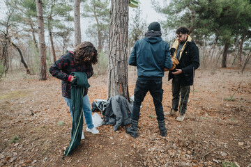 Three young friends gather and prepare their campsite in the midst of a tranquil forest, surrounded...