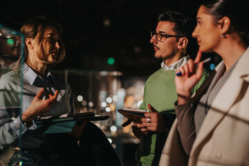 People discussing at a museum exhibit, highlighting collaboration, education, and cultural appreciation, with one person gesturing expressively amidst a dimly-lit, sophisticated interior setting.