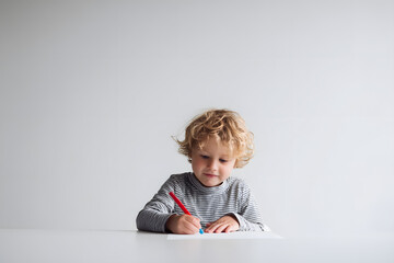 Fototapeta premium Adorable Toddler Drawing with Crayons at Bright White Table, Creative Childhood Moment