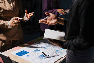 Close up of hand teamwork business group are meeting working overtime and brainstorming about business financial and marketing on paperwork and presentation.