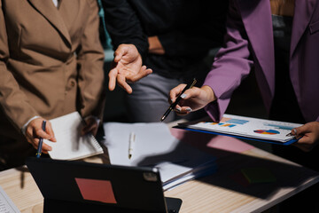 Close up of hand teamwork business group are meeting working overtime and brainstorming about business financial and marketing on paperwork and presentation.