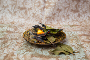 Burning bay leaves pile ,Laurus nobilis, indian traditional remedy for anxiety, soft focus close up