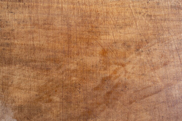 Overused chopping board with cuts and scratches, soft focus close up