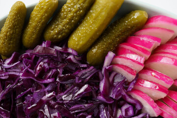 appetizer close-up - pickled cucumbers and red cabbage and radishes