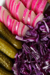 appetizer close-up - pickled cucumbers and red cabbage and radishes