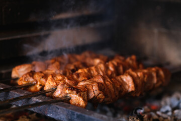 Shish kebab pork meat outdoors under charcoal.