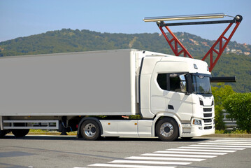 White Trailer Cargo Truck at Highway Scanning Station with Mountain View